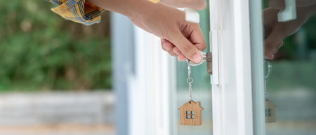 Landlord key for unlocking house is plugged into the door. Second hand house for rent and sale. Owner use hand unlock door mortgage for new home, buy, sell, renovateの写真素材