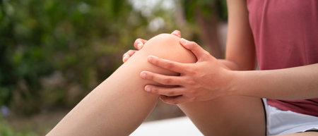 Asia female athlete or spot woman having knee injury due to ligament inflammation, knee pain due to exercise, massage, muscle relaxation, rheumatoid arthritis, gait disturbance,の写真素材