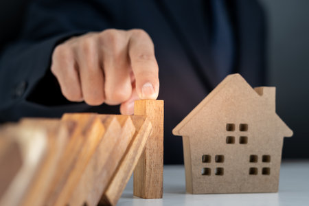 insurance with hands protect domino. Businessman hands stop dominoes falling in house crisis. business risk control and planning and strategies to run preventの写真素材