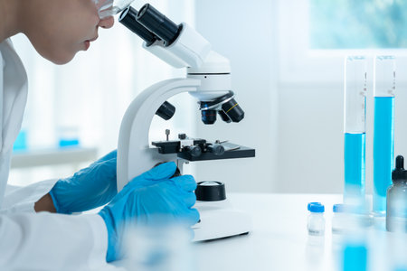 Scientist analyze biochemical samples in advanced scientific laboratory. Medical professional use microscope look microbiological developmental of viral.の写真素材