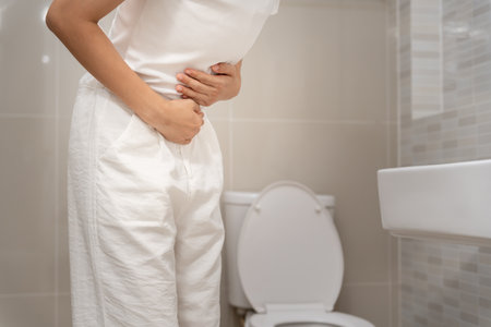 Constipation and diarrhea in bathroom. Hurt woman touch belly  stomach ache painful. colon inflammation problem, toxic food, abdominal pain, abdomen, constipated in toilet,の写真素材