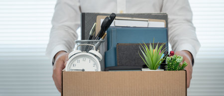 Stressful businessmen will resign from the company. lifting a brown paper box that holds personal items. resignation, job placement and vacancies concept.の写真素材