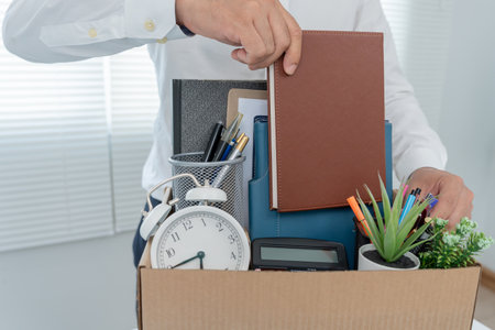 Stressful business men will resign from the company. Male keep equipment for work and personal items on paper box. resignation, job placement and vacancies concept.の写真素材