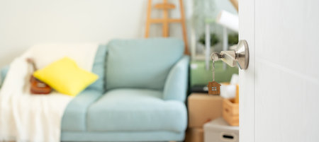 Moving house, relocation. The key was inserted into the door of the new house, inside the room was a cardboard box containing personal belongings and furniture.の写真素材