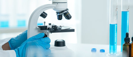Scientist analyze biochemical samples in advanced scientific laboratory. Medical professional use microscope look microbiological developmental of viral.の写真素材