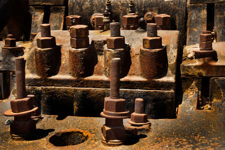 screws, nuts and bolts sticking out of  rusty metal. Abstract, background
