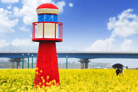 Red lighthouse in rapeseed fieldの写真素材