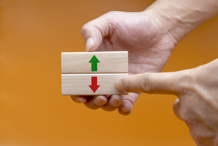 The hand that selects down among the wooden blocks marked with the up and down icon