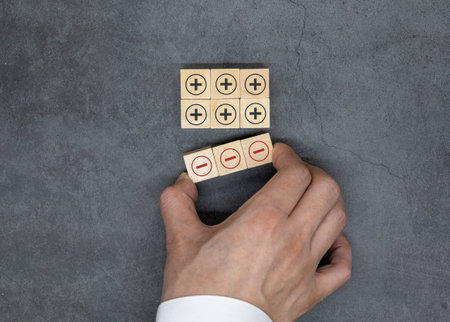 Plus and minus icons on wooden cubes. Separate the negative from positive, removing the weaknesses or negativity, positive thinking, negative feedback or subtractionの写真素材