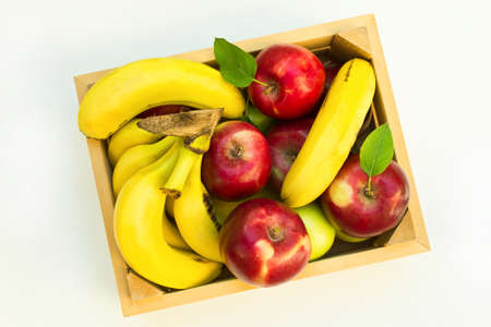 Fresh bananas and apples in box on white background.の写真素材