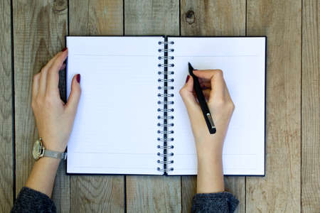 Woman with pen in hands.