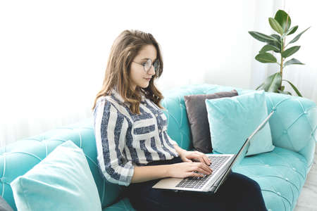 Young woman working on laptop at home.