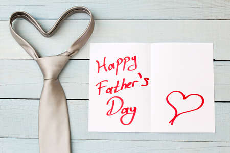 Happy Father's Day card and necktie on blue wooden background.の写真素材