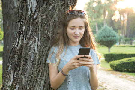 Young woman using smartphone in the park.の写真素材