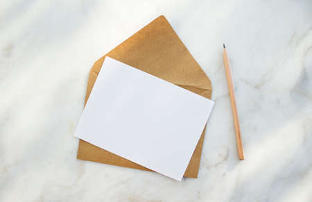 Envelope, white blank paper and pencil on a white background.の写真素材
