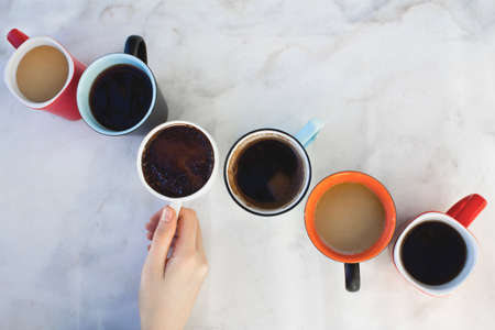 Woman hand holding a coffee cup on white background.の写真素材