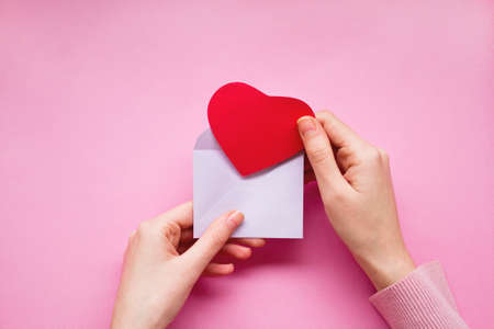 Woman hands holding envelope and heart shape card.の写真素材