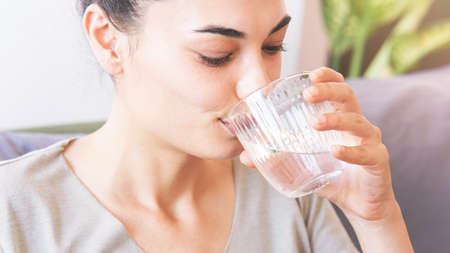 Young woman drinking a glass of water