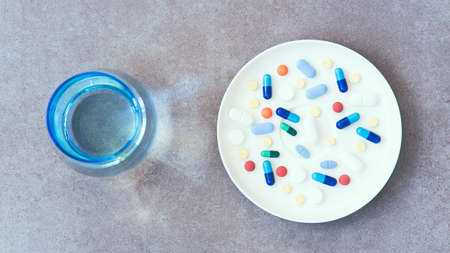 A lot of pills and glass of waterの写真素材