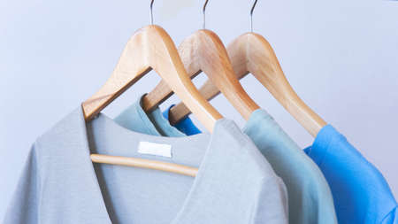 Women clothes hanging on wooden hangers in the storeの写真素材