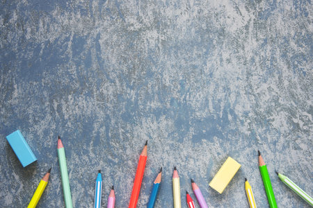 Pencils and erasers on textured gray backgroundの写真素材