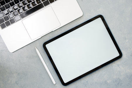 Laptop, digital tablet and pen on office desk.