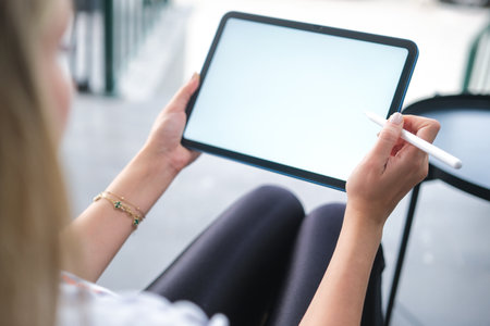 Woman hand working on blank white screen digital tablet in coffee shop.の写真素材