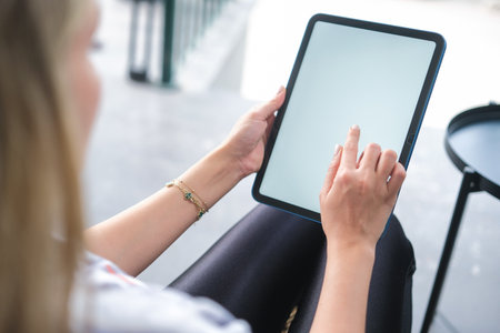 Woman hand working on blank white screen digital tablet in coffee shop.の写真素材