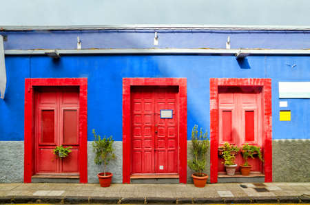 Blue house with three red doors in the old Town of San Cristobal de La Laguna. Architectural detail of creative colorful house. Color blocks architecture background. Tenerife, Canary Islandsの写真素材