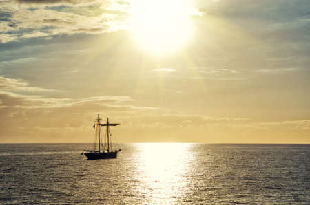 Sailing boat silhouette at sunset in Los Cristianos, Tenerife, Spain.