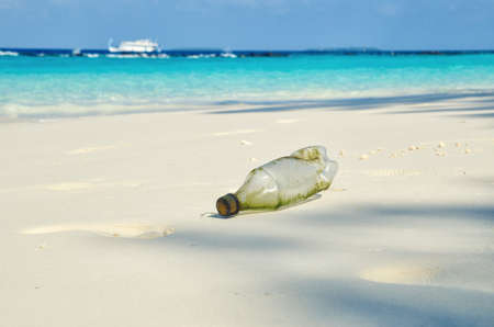 Plastic single-use bottle on beautiful white sand tropical beach.の写真素材
