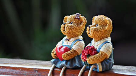 Lovely bear couple holding heart and roses. Valentine or anniversary background.の写真素材