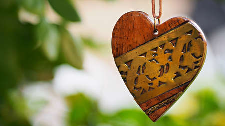 Wooden heart hanging with green background. Valentine background.