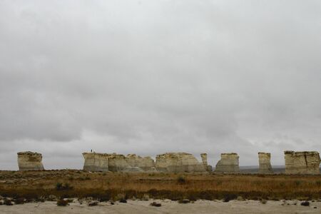 Monument Rocks, Kansas, distant view with two men and cloudsの写真素材