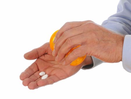 Dispensing pills from a prescription bottle into his hand set against a white background.の写真素材