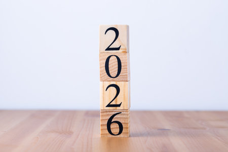 Wooden blocks forming 2026 in vertical column on light wooden table and gray background, vertical...
