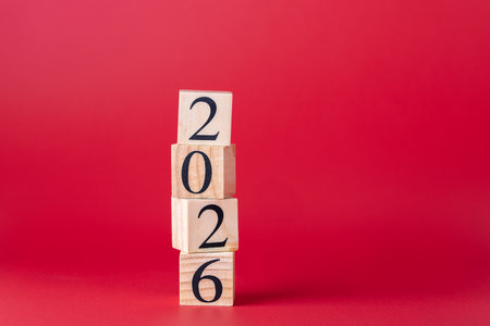 Misaligned wooden blocks forming the number 2026 in ascending order, placed on a red background....