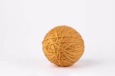 Yellow yarn ball on white background, minimalist and clean style with copy space. Concept of handmade crafts and cozy lifestyleの写真素材