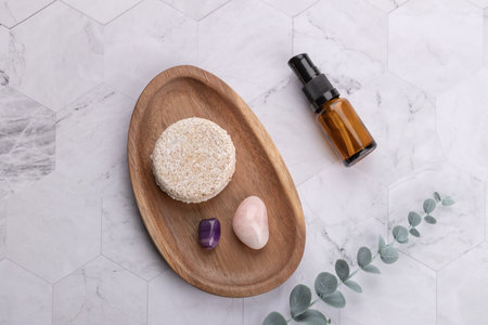 Top horizontal view of solid shampoo bar on wooden tray with amber cosmetic bottle, decorative...