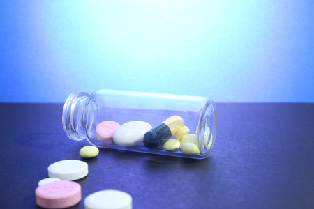Capsule pills medical, white and pink, on a blue background.の写真素材