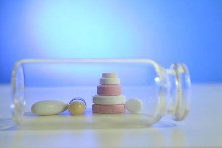 Capsule pills medical, white and pink, on a blue background.の写真素材