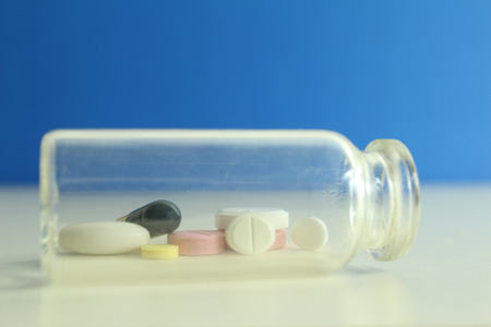 Capsule pills medical, white and pink, on a blue background.