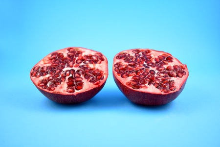 Juicy pomegranate stock images. Pomegranate on a blue background. Juicy pieces of pomegranate. Split pomegranateの写真素材