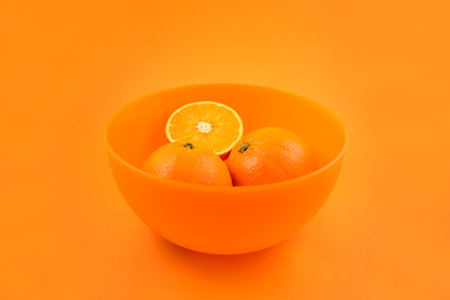 Oranges in an orange bowl stock images. Orange on orange background. Juicy pieces of oranges. Bowl with orangesの写真素材