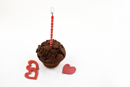 Romatic muffin with candle stock images. Chocolate muffin with hearts on a white background. Sweet party pastry. Valentines Day conceptの写真素材