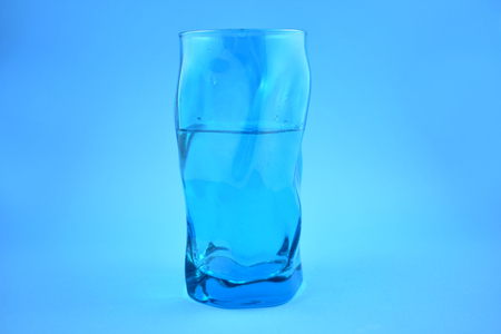 Glass of water stock images. Blue glass of water on a blue background. Water blue backgroundの写真素材