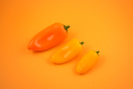 Orange peppers stock images. Orange peppers on a orange background. Group of peppersの写真素材