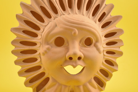 Ceramic Sun Face stock images. Ceramic sun on a yellow background. Sun decoration. Ceramic Sun Lamp. Sun clay lampの写真素材