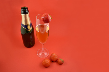 Champagne with strawberries stock images. Strawberries with champagne. Champagne on red background with copy space for text. Festive red background. Valentines Day conceptの写真素材