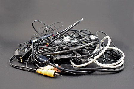 Tangled cables and connectors stock images. Tangle of cables on a black background. Plastic...